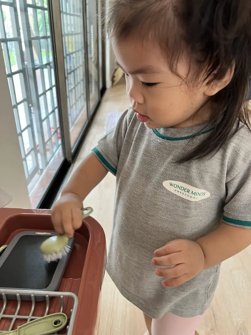 A girl scooping with a spoon from a tub