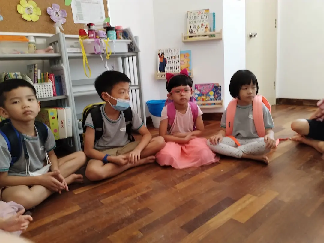 Children sitting cross-legged on the floor in a circle