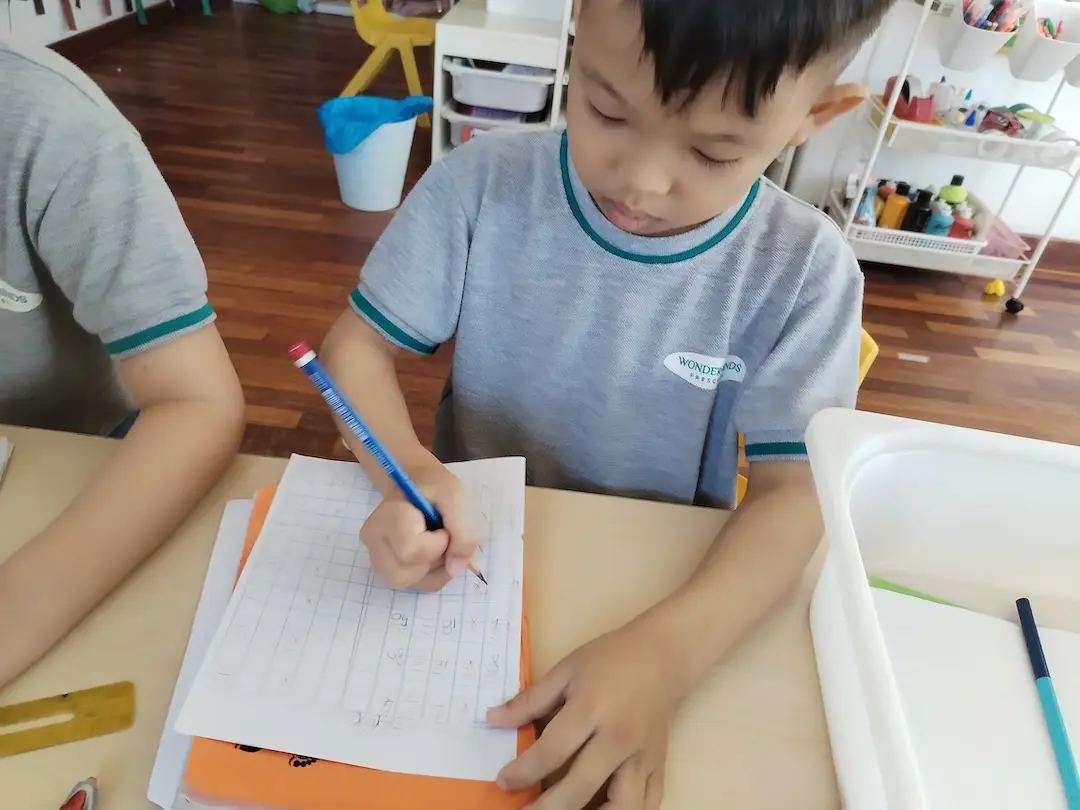 A boy writing on lined paper