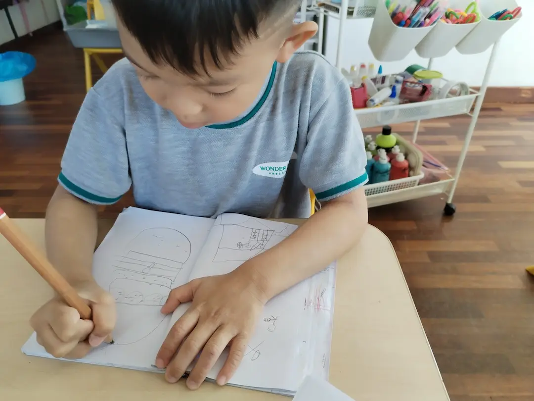 A boy drawing in a notebook