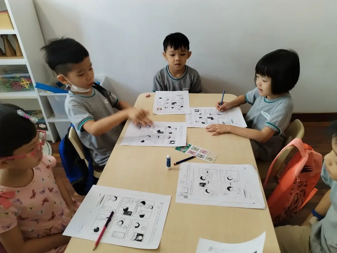 Children working on worksheets at a table