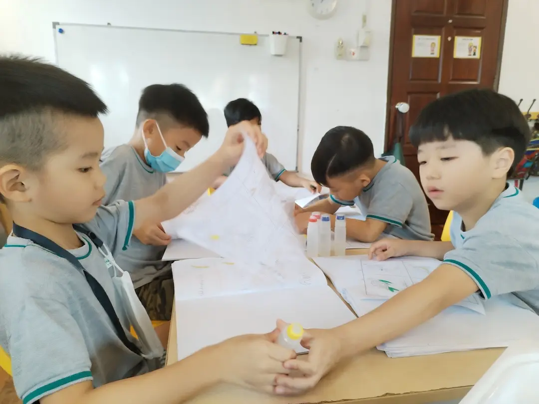 Children drawing together on large sheets of paper