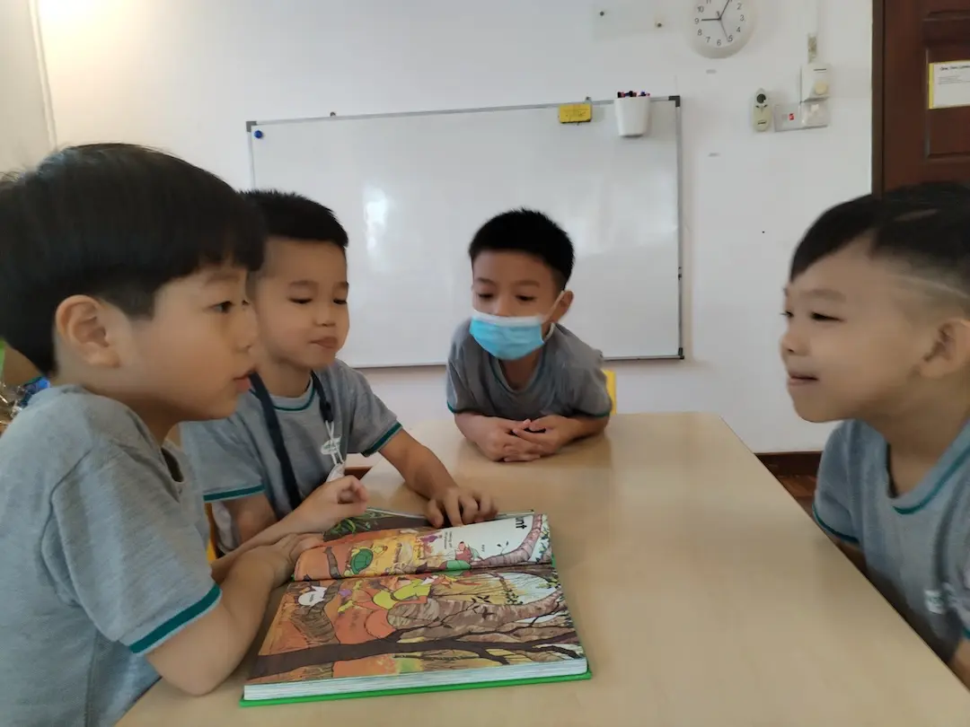 Children looking at a picture book at a table