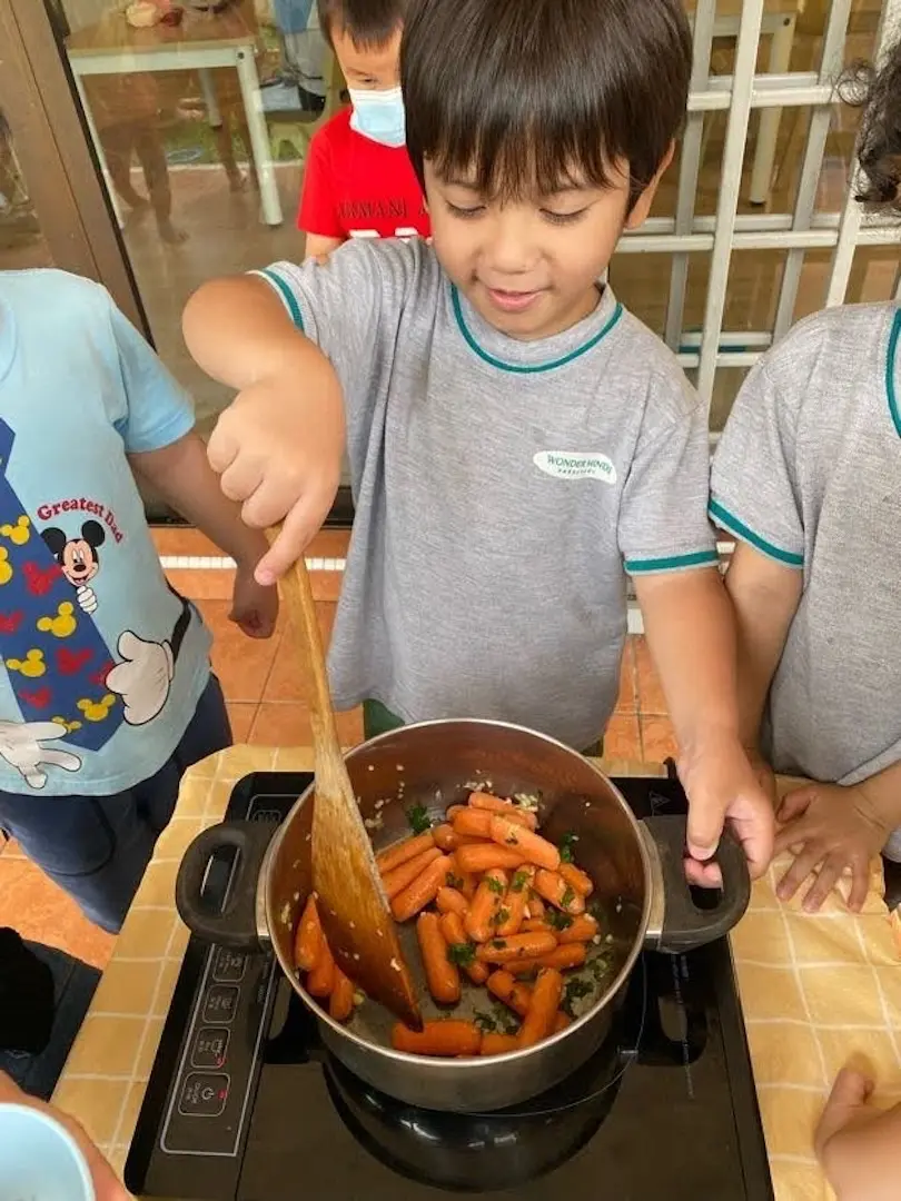 Children stirring a pot of carrots