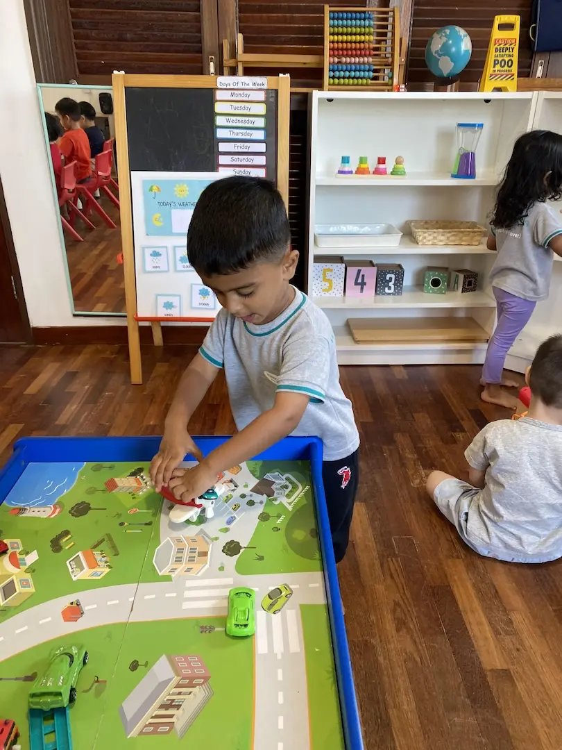 A boy placing pieces on a map activity tray