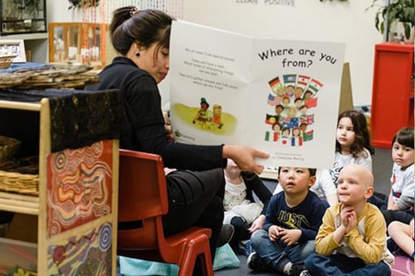 kindergarten teacher reading a story to a group of children