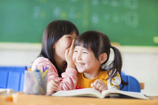 two girls smiling in a classroom