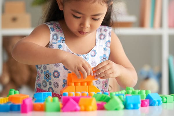 little girl playing with colourful blocks
